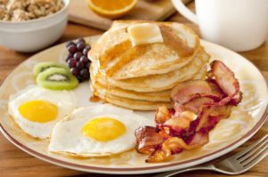 Pancakes, bacon, eggs, and fruit.