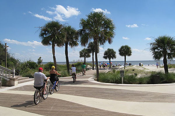 A beach access point with people riding their bikes out to bike on the beach